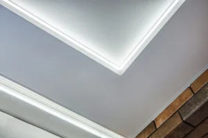 Detail rohu napínacieho stropu s nepriamym LED podsvietením pri stene.
