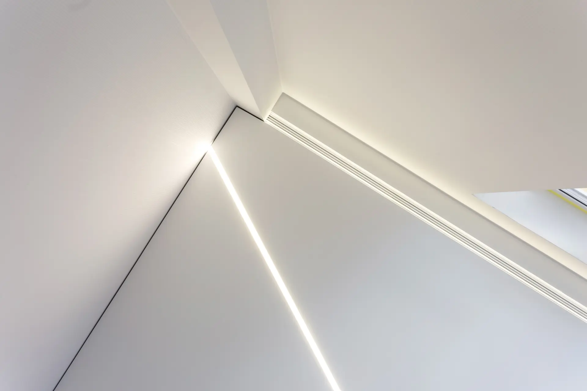 Moderný napínací strop s diagonálnou LED líniou a nepriamym osvetlením.