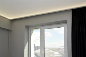 Napínací strop s nepriamym LED osvetlením pri okne v modernom interiéri.
