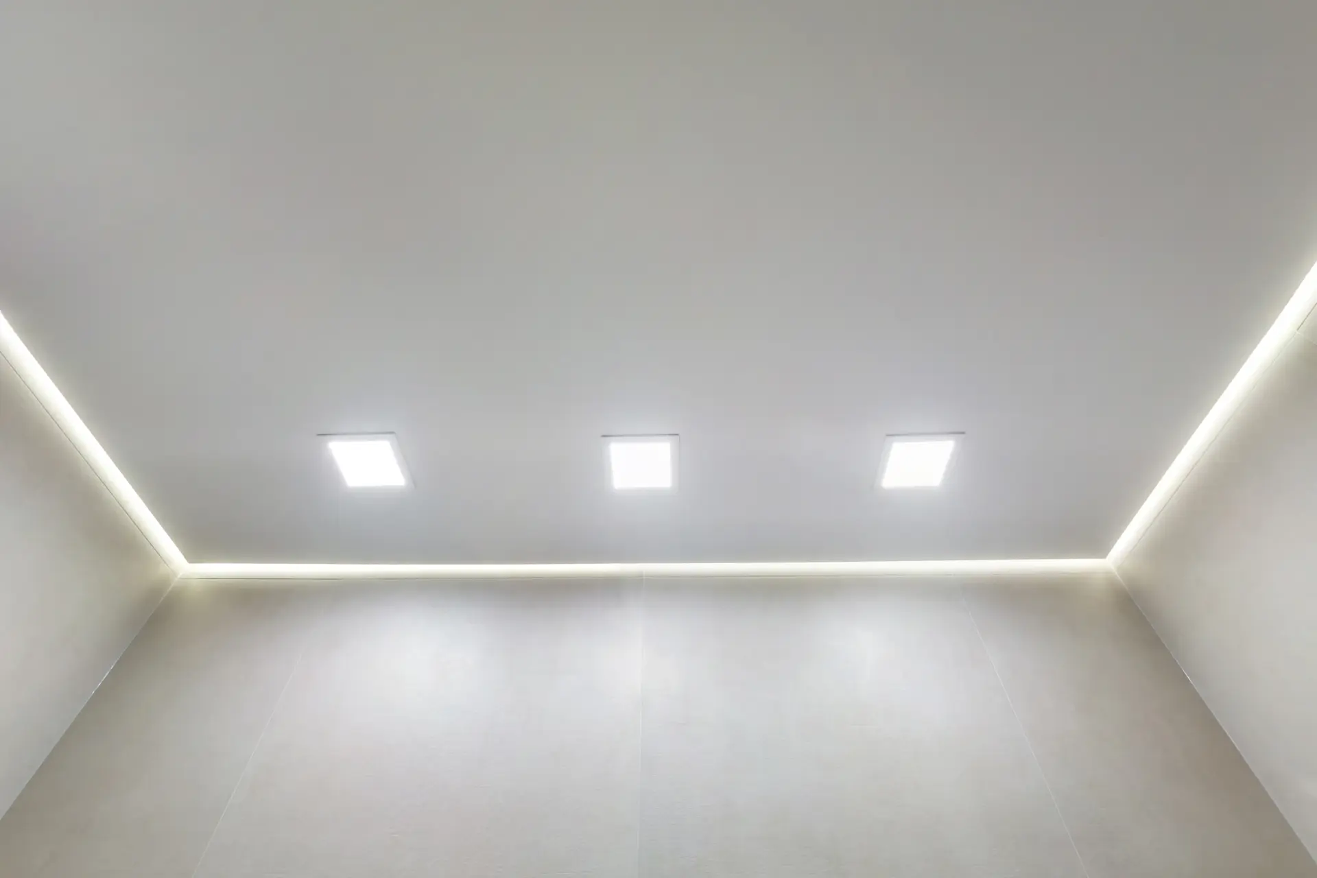 Napínací strop s hranatými LED panelmi a nepriamym podsvietením po obvode.